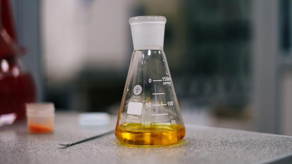 Kolba Erlenmeyera szklana ze skalą na stole laboratoryjnym